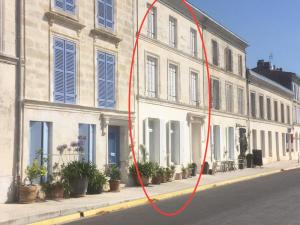 Mortagne-sur-GirondeLa Maison du Port的红水管附在街道上的建筑物上