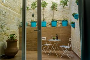 ŻabbarTa' Ġilard - Lovely Renovated Holiday Home的墙上有桌子和盆栽植物的房间