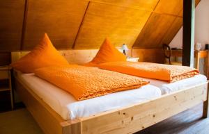 Dachsberg im Schwarzwald克洛斯特维何霍夫酒店的木床上的2个橙色枕头