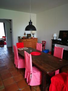 Mortagne-sur-GirondeLa Maison du Port的用餐室配有木桌和粉红色椅子