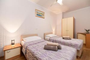 尼亚卢卡Apartments Dea Caeli的一间卧室设有两张床和床头柜