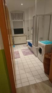 AmmendorfHalle Saale 402的一间带洗衣机的浴室和瓷砖地板