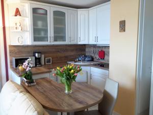 佩尔泽哈肯Appartement Meeresbrise的厨房配有木桌,上面有花瓶