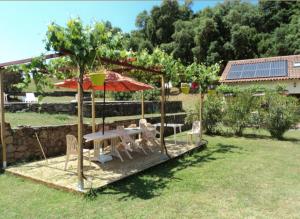 CarbucciaGîtes Carbuccia en Corse avec piscine chauffée的院子里的桌子和椅子以及雨伞