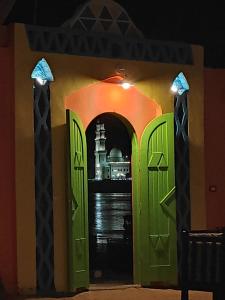 阿斯旺Maghrabi's Guest house的拥有绿色门的建筑物入口