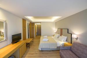 奥林匹亚欧罗巴奥林匹亚酒店的酒店客房,配有床和沙发
