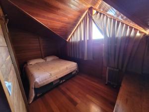 邦雅尔丁-达塞拉Hotel Fazenda Boutique Terra do Gelo的一间小卧室,配有一张位于木屋内的床铺