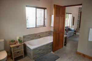 帕尔Sol Montis Guest Cottage的带浴缸和卫生间的浴室。