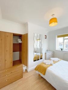 格雷夫森德3 bed duplex flat, free WIFI & Netflix, Ideal for contractors的卧室配有一张白色大床和木制橱柜。