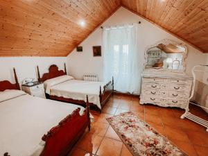 蓬特亚雷亚斯Pazo Dos Remedios的一间卧室设有两张床和木制天花板