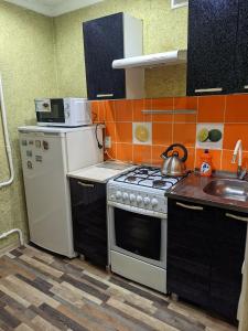 休钦斯克Квартира в районе жд вокзала的小厨房配有炉灶和水槽