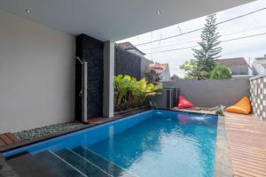 新加拉惹Josh Guest House的一座房子后院的游泳池