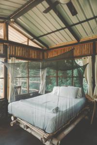BalgueLa Bambouseraie的一间带天蓬床的卧室,位于带窗户的房间内