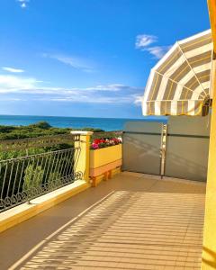 米萨诺阿德里亚蒂科Hotel Caravel B&B的阳台配有遮阳伞,享有海景。