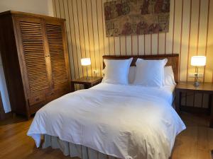 Oza dos Ríos莱克托拉尔德辛斯酒店的一间卧室配有一张带两盏灯的大型白色床。