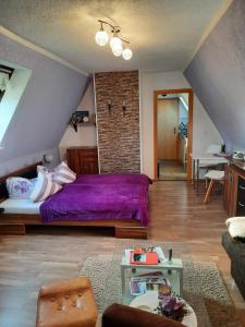 GarzFerienwohnung Garz的阁楼上一间卧室配有一张紫色床