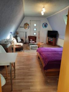 GarzFerienwohnung Garz的一间带紫色床的卧室和一间客厅
