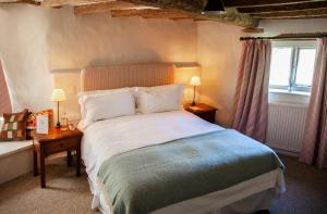 希普顿－安德威奇伍德The Lamb Inn的一间卧室设有一张大床和一个窗户。