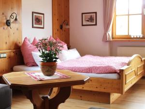 雷特温克尔Schmuckhäusl的一间卧室配有一张床和一张带盆栽的桌子
