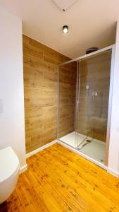 菲尔特Uraha Apartments Fürth的铺有木地板,设有带卫生间和淋浴的浴室