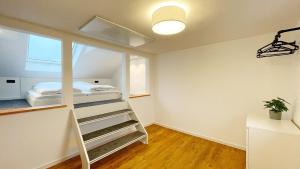 菲尔特Uraha Apartments Fürth的一间卧室设有通往一张床的楼梯