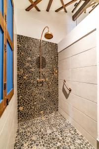 杰里科Casa Jacaranda Hotel Boutique的带淋浴的浴室(带石墙)