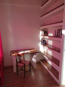 托雷佩利切Appartamento con vista a Torre Pellice的书架的房间里一张桌子