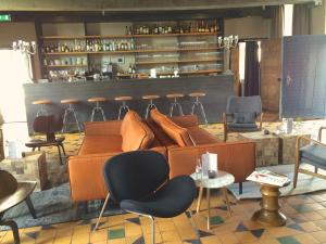 库福尔登Fletcher Hotel-Restaurant Kasteel Coevorden的一间配有沙发和椅子的房间和一间酒吧