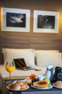 特雷索波利斯城际特雷索波利斯酒店的一张桌子,上面放着一盘食物和一杯葡萄酒