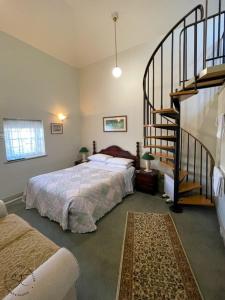 波特兰维多利亚之家住宿加早餐旅馆的一间卧室设有一张床和一个螺旋楼梯