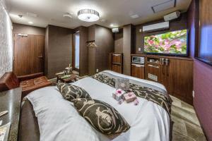 仙台Hotel ＧEM的一间卧室配有一张大床和一台平面电视