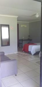MʼBazwaneMbazwana Inn的一间卧室配有一张床和一个沙发