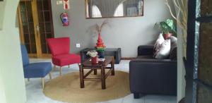 MʼBazwaneMbazwana Inn的客厅配有沙发和桌椅