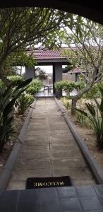 MʼBazwaneMbazwana Inn的花园中种有树木和建筑的走道