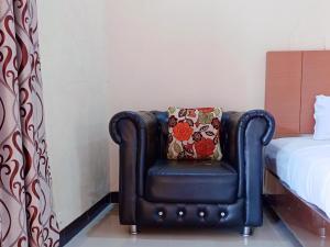 TesRedDoorz Syariah Near Danau Tes Bengkulu的一张黑椅子,床边有枕头
