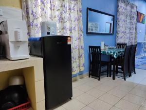 Rantau PanjangRiverview Homestay - Homestay Tepi Sungai Golok的厨房配有桌子和黑冰箱。