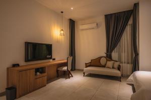 麻坡Alivila的酒店客房配有电视、床和椅子