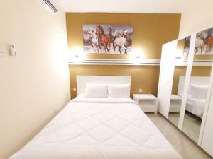 三宝垄Rons City Hotel near Simpang Lima Semarang Mitra RedDoorz的一间小卧室,配有白色的床和架子