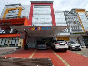 三宝垄Rons City Hotel near Simpang Lima Semarang Mitra RedDoorz的停车场,停车场停在大楼前