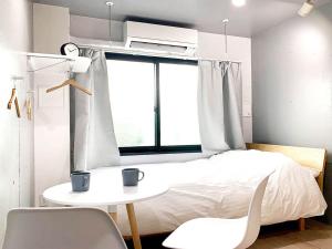 东京Itos Ebisu的卧室配有一张床和一张桌子及椅子