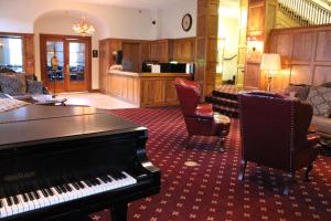 博尔德城博尔德大坝酒店的一间设有钢琴的房间和一间带椅子的客厅