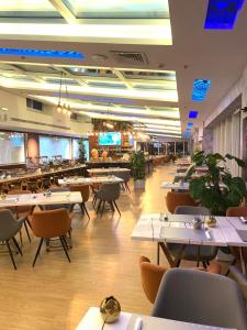 布赖代Brand Al Qassim Hotel的一间带桌椅的用餐室和一间餐厅