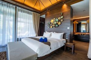 高兰Nirvana Beach Resort, Koh Lanta SHA Extra Plus的一间卧室配有一张大床,上面有两条蓝色的毛巾