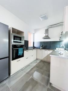 扎马迪克拉普卡别墅公寓的厨房配有白色橱柜和不锈钢用具
