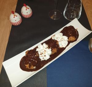 Les RosiersLogis Loire Hotel - Les Cocottes Restaurant的桌子上盘子里的两块巧克力覆盖的甜甜圈