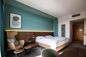 菲尔斯滕费尔德附近洛伊佩尔斯多夫达桑临驰 - 洛泊多夫温泉酒店的配有一张床和一把椅子的酒店客房