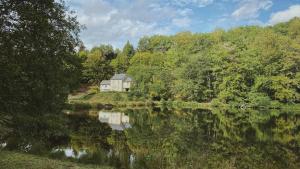 Saint-Hilaire-les-CourbesAppartement aux Sources de la Chabanne的湖畔小山上的房屋