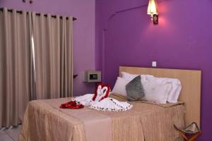 尼耶利Mpeta House的紫色卧室,配有一张带两个娃娃的床