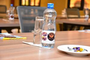尼耶利Mpeta House的盘子旁边的桌子上放一瓶水