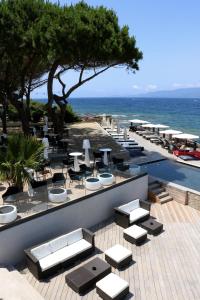 卡尔卡托吉奥卡斯特尔欧西诺酒店的一个带桌椅的庭院和大海